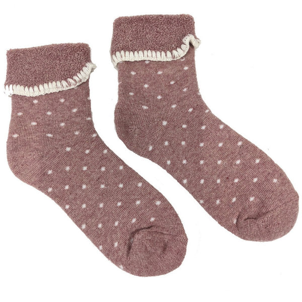 A pair of pink socks with small white polka dots and a cuff at the top, made from a wool-blend fabric.